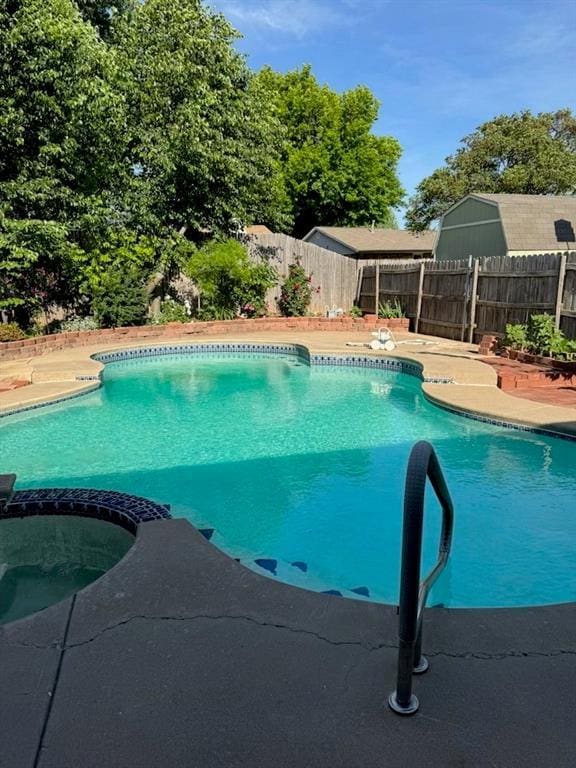 view of pool featuring a pool with connected hot tub, a fenced backyard, and a patio