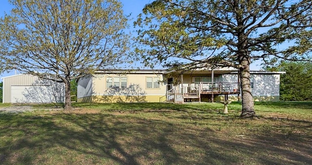 rear view of house with an outdoor structure, a detached garage, and a lawn