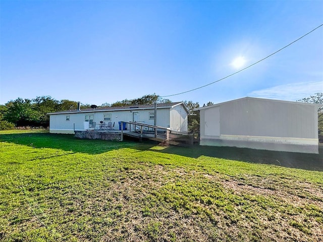 back of property with a wooden deck and a yard