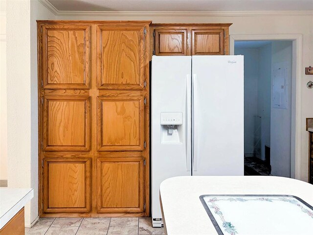 kitchen featuring light countertops, crown molding, brown cabinetry, and white refrigerator with ice dispenser