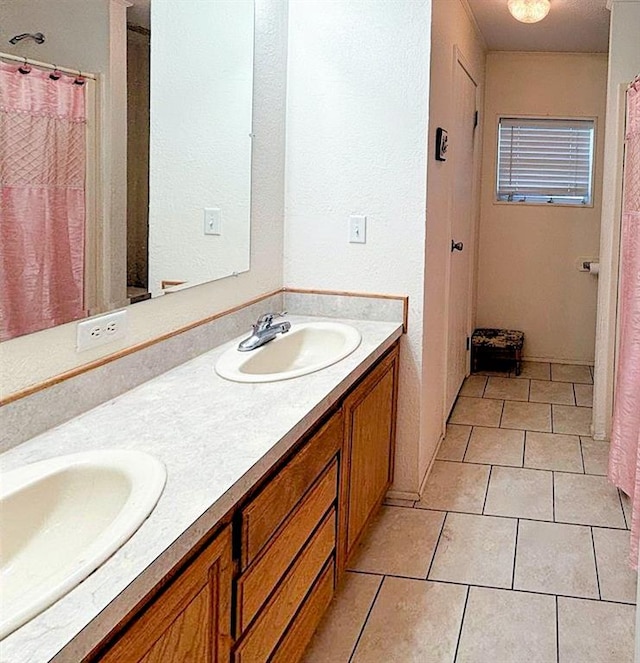 full bathroom featuring tile patterned flooring, a sink, and double vanity