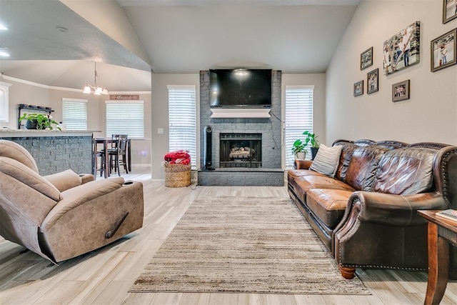 716 SW 149th Pl, Oklahoma City, OK 73170 - living room with vaulted ceiling, baseboards, a notable chandelier, wood finished floors, and a brick fireplace