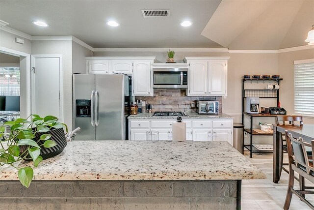 716 SW 149th Pl, Oklahoma City, OK 73170 - kitchen with white cabinetry, visible vents, crown molding, and stainless steel appliances