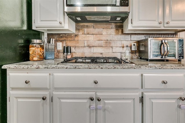 716 SW 149th Pl, Oklahoma City, OK 73170 - kitchen featuring white cabinetry, tasteful backsplash, and stainless steel appliances