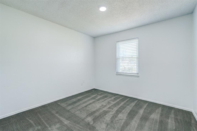 empty room with recessed lighting, a textured ceiling, baseboards, and dark colored carpet
