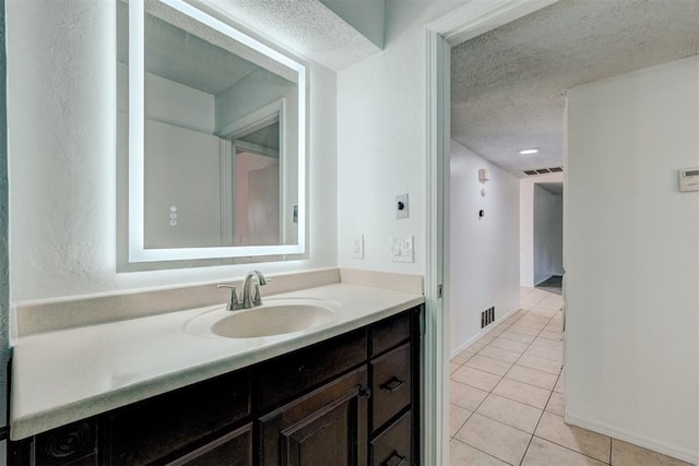 bathroom featuring a textured ceiling, visible vents, tile patterned floors, and vanity