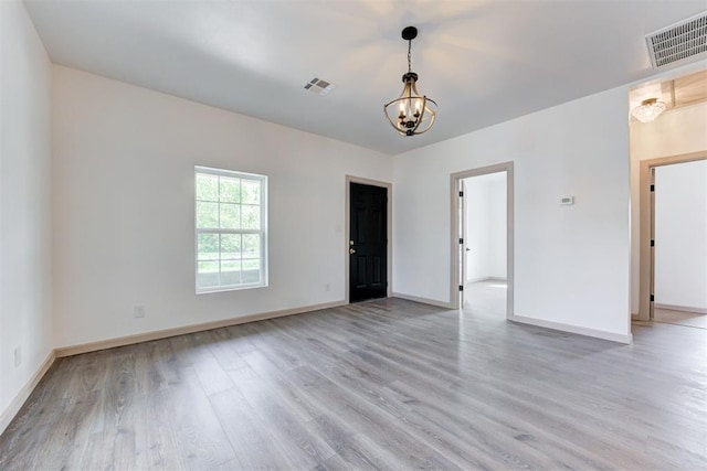 1608 NE 21st St, Oklahoma City, OK 73111 - unfurnished room with baseboards, a chandelier, visible vents, and light wood-style flooring