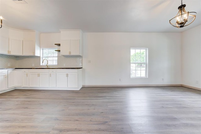 1608 NE 21st St, Oklahoma City, OK 73111 - kitchen featuring a wealth of natural light, open shelves, an inviting chandelier, and light wood-style flooring