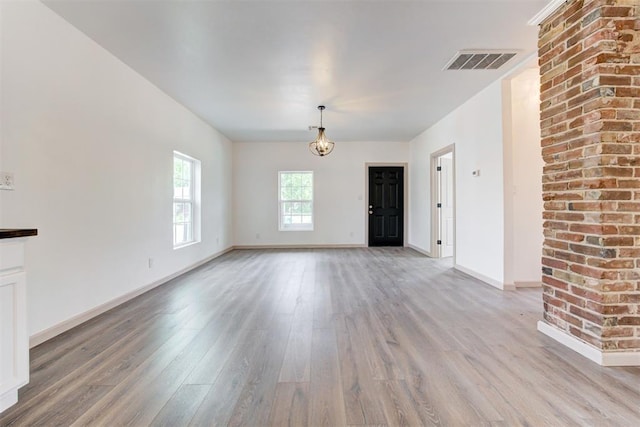 1608 NE 21st St, Oklahoma City, OK 73111 - unfurnished living room with baseboards, visible vents, and light wood-style floors
