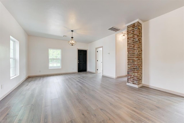 1608 NE 21st St, Oklahoma City, OK 73111 - unfurnished living room with a chandelier, light wood-type flooring, visible vents, and baseboards
