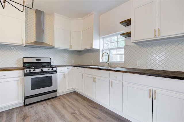 1608 NE 21st St, Oklahoma City, OK 73111 - kitchen with white cabinets, a sink, stainless steel gas range, butcher block countertops, and wall chimney range hood