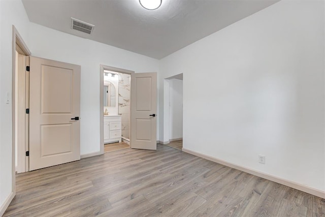 1608 NE 21st St, Oklahoma City, OK 73111 - unfurnished bedroom with light wood-style flooring, visible vents, baseboards, and connected bathroom