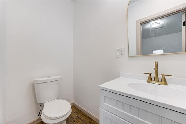 1608 NE 21st St, Oklahoma City, OK 73111 - half bathroom featuring toilet, baseboards, visible vents, wood finished floors, and vanity