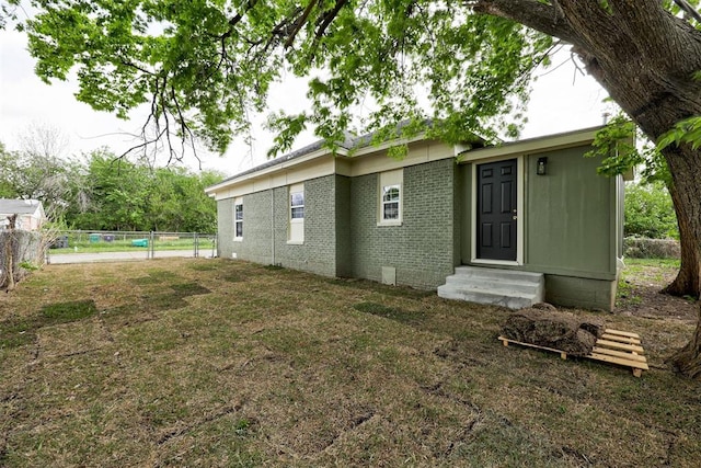 1608 NE 21st St, Oklahoma City, OK 73111 - rear view of house featuring brick siding, entry steps, a lawn, and fence