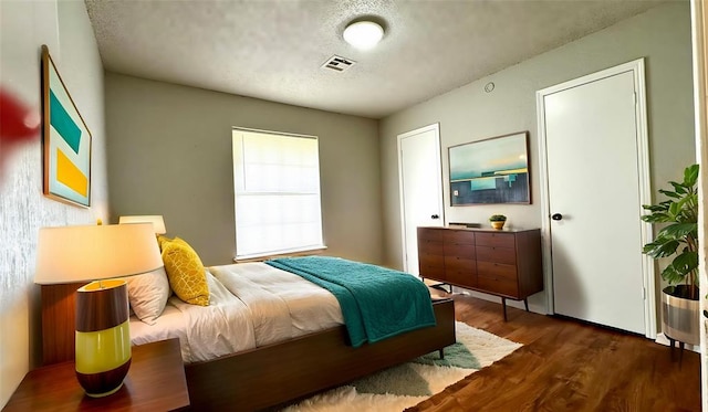 2900 Pheasant Run, Edmond, OK 73012 - bedroom featuring dark wood finished floors and a textured ceiling