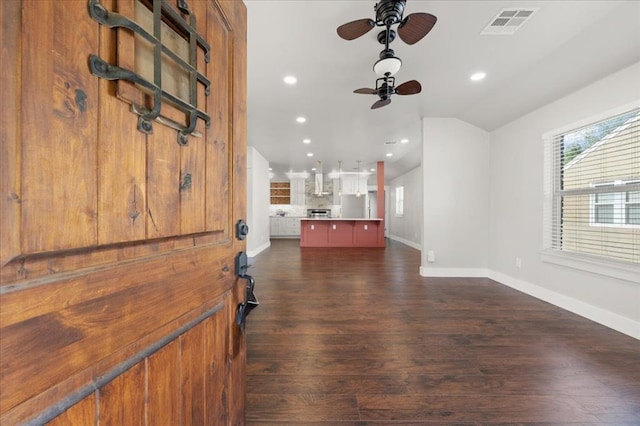interior space with dark wood-style floors, recessed lighting, visible vents, vaulted ceiling, and baseboards