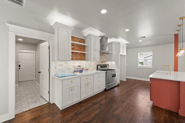 kitchen with high end stove, visible vents, light countertops, baseboards, and wall chimney exhaust hood