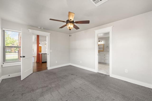 unfurnished bedroom featuring connected bathroom, a ceiling fan, visible vents, baseboards, and carpet floors