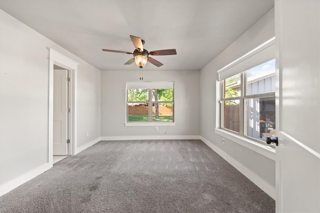 empty room with a ceiling fan, baseboards, and carpet floors