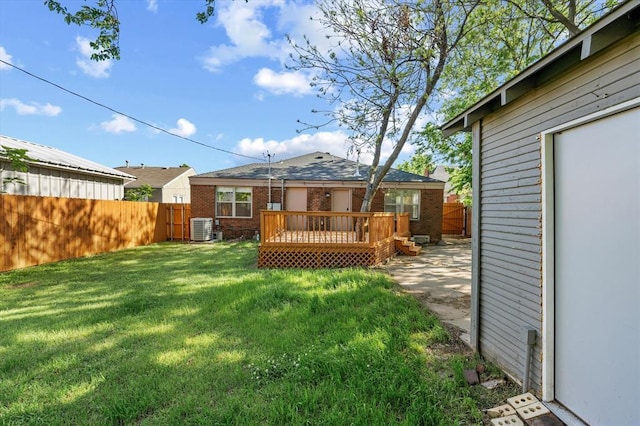 view of yard with a deck, central AC unit, and fence