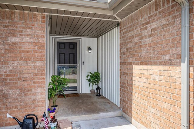 view of exterior entry featuring brick siding