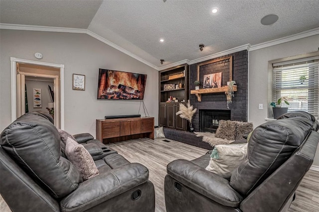 living area with ornamental molding, wood finished floors, a textured ceiling, and a fireplace