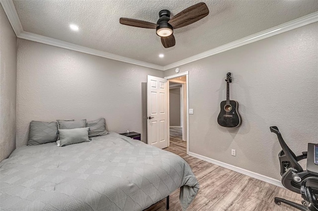 bedroom featuring a ceiling fan, ornamental molding, wood finished floors, and a textured ceiling