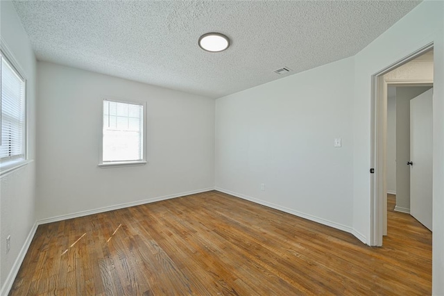 3210 SE 16th St, Oklahoma City, OK 73115 - empty room with wood-type flooring, a textured ceiling, and baseboards