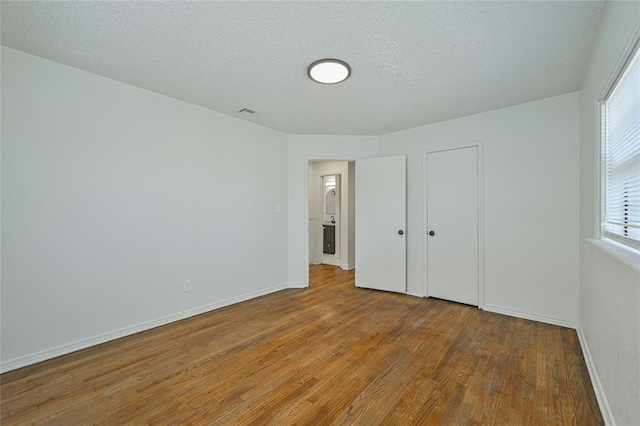 3210 SE 16th St, Oklahoma City, OK 73115 - unfurnished bedroom featuring hardwood / wood-style floors, baseboards, a textured ceiling, and a closet