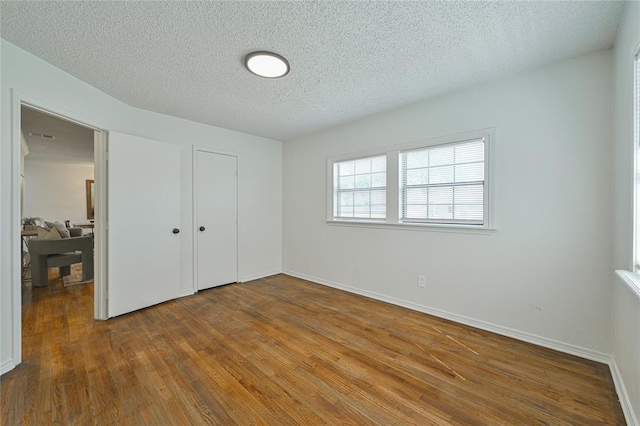 3210 SE 16th St, Oklahoma City, OK 73115 - unfurnished bedroom featuring a textured ceiling, wood-type flooring, baseboards, and a closet