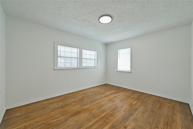 3210 SE 16th St, Oklahoma City, OK 73115 - unfurnished room featuring wood finished floors, a textured ceiling, and baseboards