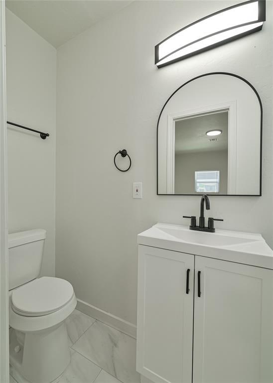 3210 SE 16th St, Oklahoma City, OK 73115 - bathroom featuring marble finish floors, toilet, vanity, and baseboards