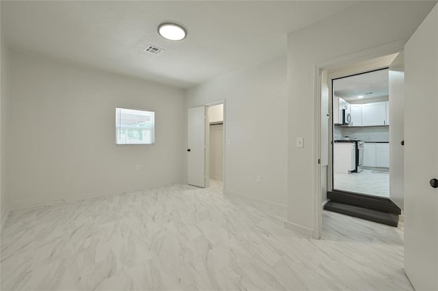 3210 SE 16th St, Oklahoma City, OK 73115 - unfurnished bedroom featuring light marble finish floors and a walk in closet