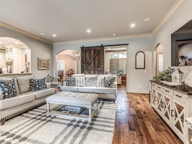 living room with plenty of natural light, arched walkways, a barn door, and hardwood / wood-style flooring