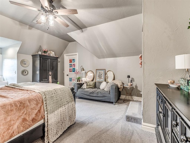 bedroom with a textured wall, light carpet, vaulted ceiling, and ceiling fan