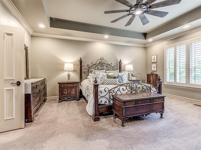 bedroom with baseboards, ornamental molding, a raised ceiling, and light colored carpet