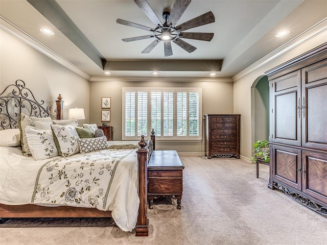 bedroom featuring ornamental molding, light carpet, baseboards, a raised ceiling, and arched walkways