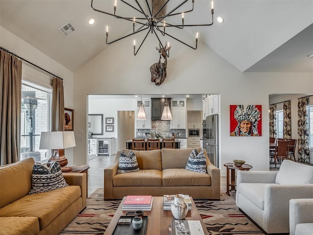 9401 Autumn Park Ln, Oklahoma City, OK 73151 - living area featuring visible vents, wine cooler, light wood-style floors, high vaulted ceiling, and a notable chandelier