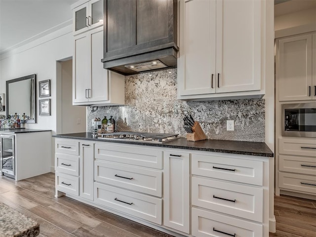 9401 Autumn Park Ln, Oklahoma City, OK 73151 - kitchen with appliances with stainless steel finishes, wood finished floors, tasteful backsplash, and glass insert cabinets