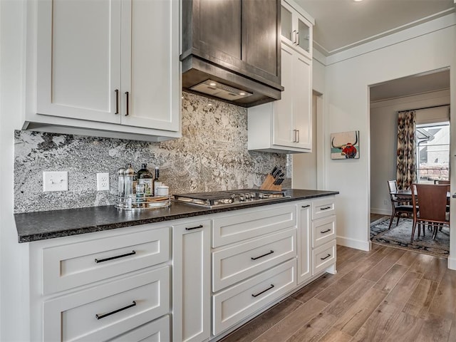 9401 Autumn Park Ln, Oklahoma City, OK 73151 - kitchen featuring tasteful backsplash, stainless steel gas cooktop, light wood-type flooring, glass insert cabinets, and white cabinetry