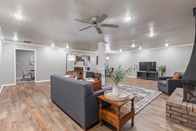 1312 N Nail Pkwy, Moore, OK 73160 - living room with a ceiling fan, ornamental molding, ornate columns, light wood-type flooring, and baseboards