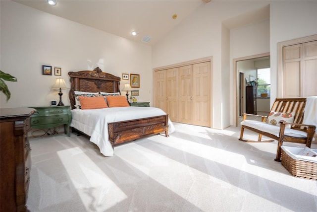 bedroom featuring light colored carpet, high vaulted ceiling, recessed lighting, visible vents, and a closet