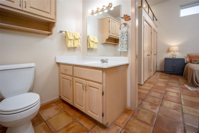 bathroom featuring vanity, baseboards, tile patterned flooring, and toilet