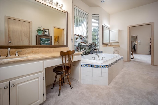 bathroom with a garden tub and vanity