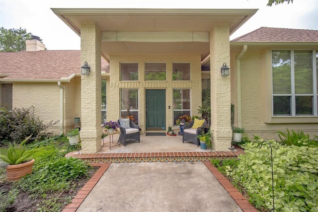 view of exterior entry featuring a shingled roof