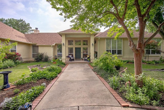 property entrance featuring a yard and a shingled roof