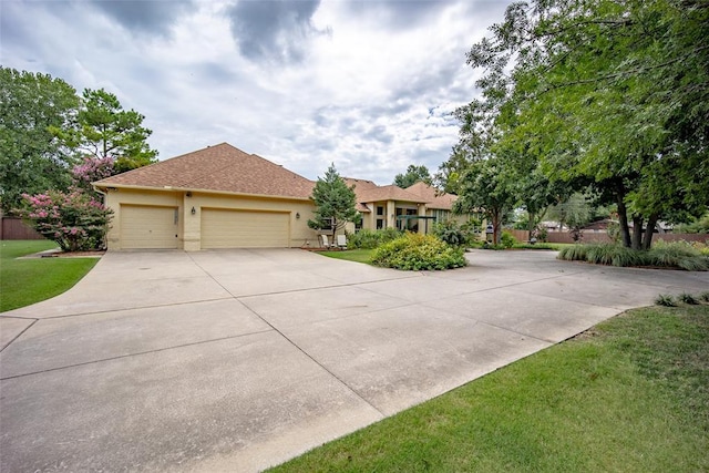 ranch-style home with stucco siding, an attached garage, driveway, and a front lawn