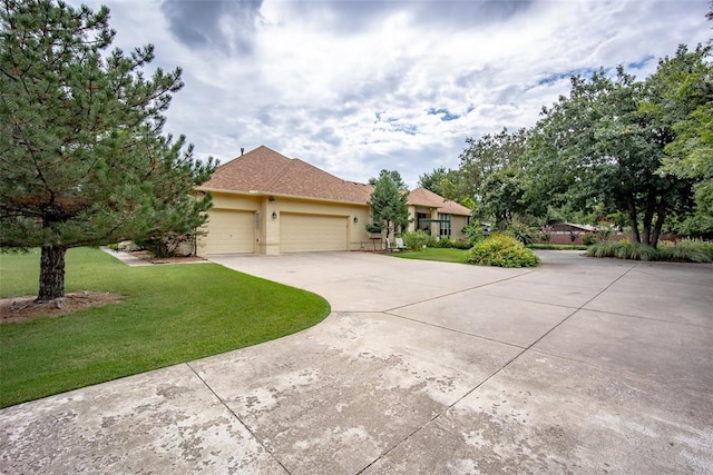 view of front of home with an attached garage, stucco siding, driveway, and a front yard
