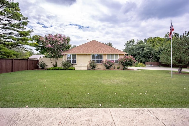 view of front of home featuring fence and a front lawn