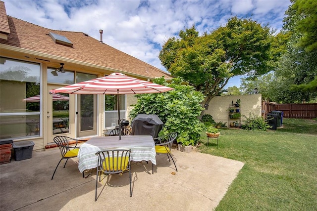 view of patio with fence, outdoor dining area, and a grill
